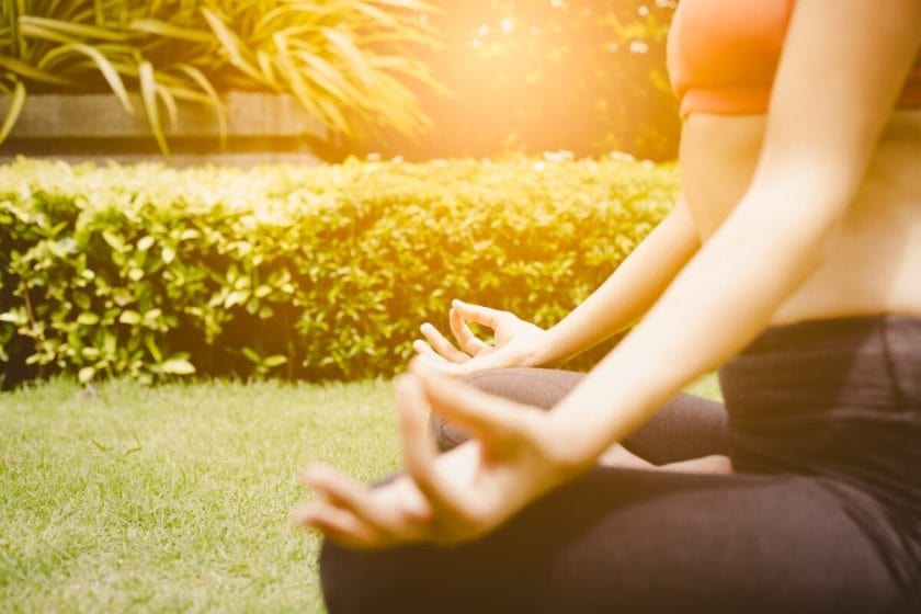 Yoga concept. Beautiful woman get meditation by lotus pose in nice garden. Yoga of lotus position make her relaxing, relieve from stress. Charming beautiful young woman wear sportswear. She feel happy